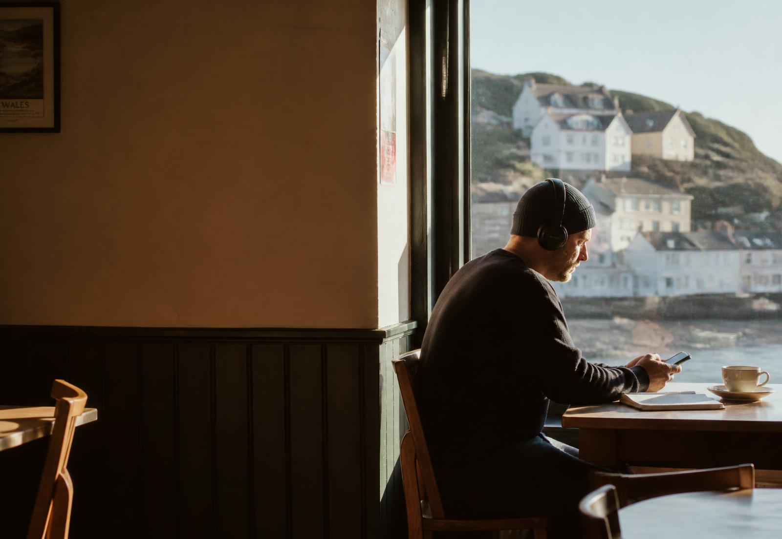 An adult listening to a Welsh lesson in a coastal café